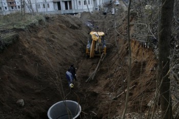 копают в лесу возле стройки, передвинув забор стройки